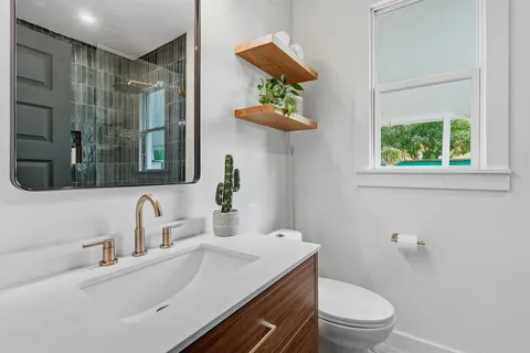 a bathroom with a sink a toilet and mirror
