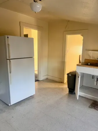 a view of a kitchen with a sink and a refrigerator