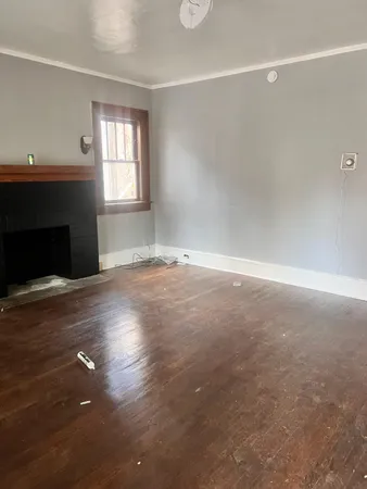 an empty room with windows and fireplace