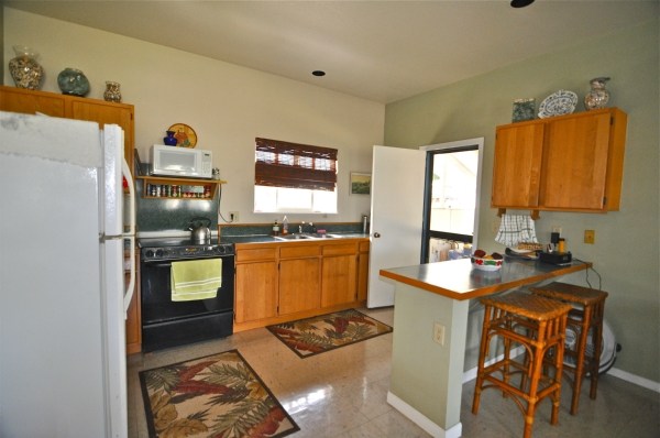 8630 Elepaio Road Kekaha, HI 96752 - Photo 10 of 20 a kitchen with granite countertop a sink stove and cabinets
