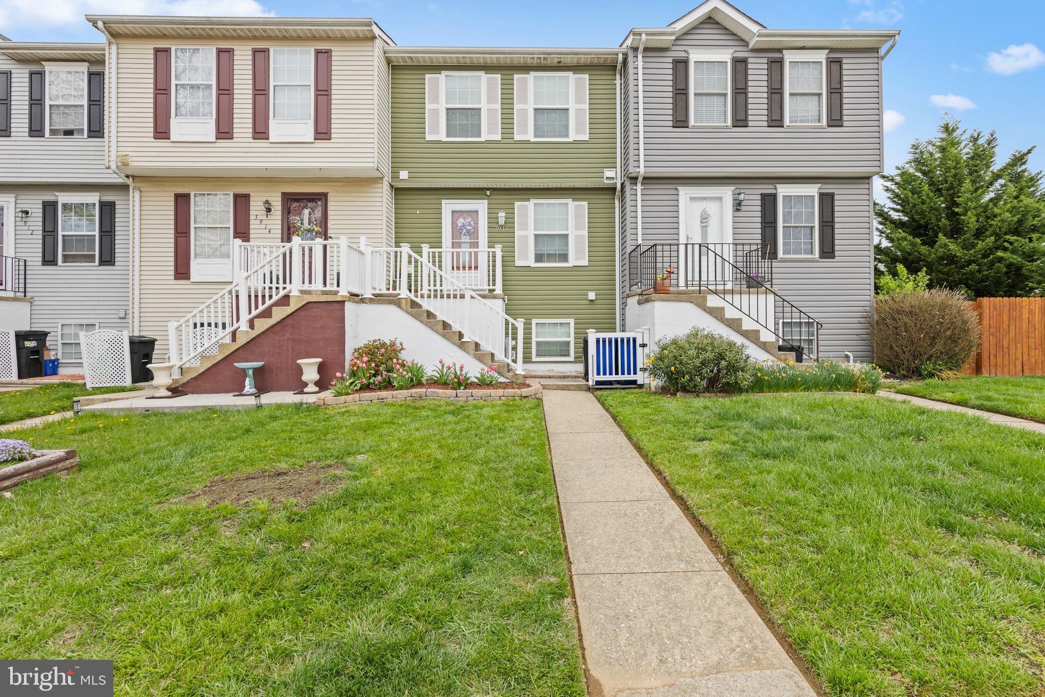 a view of a brick house with a yard and plants