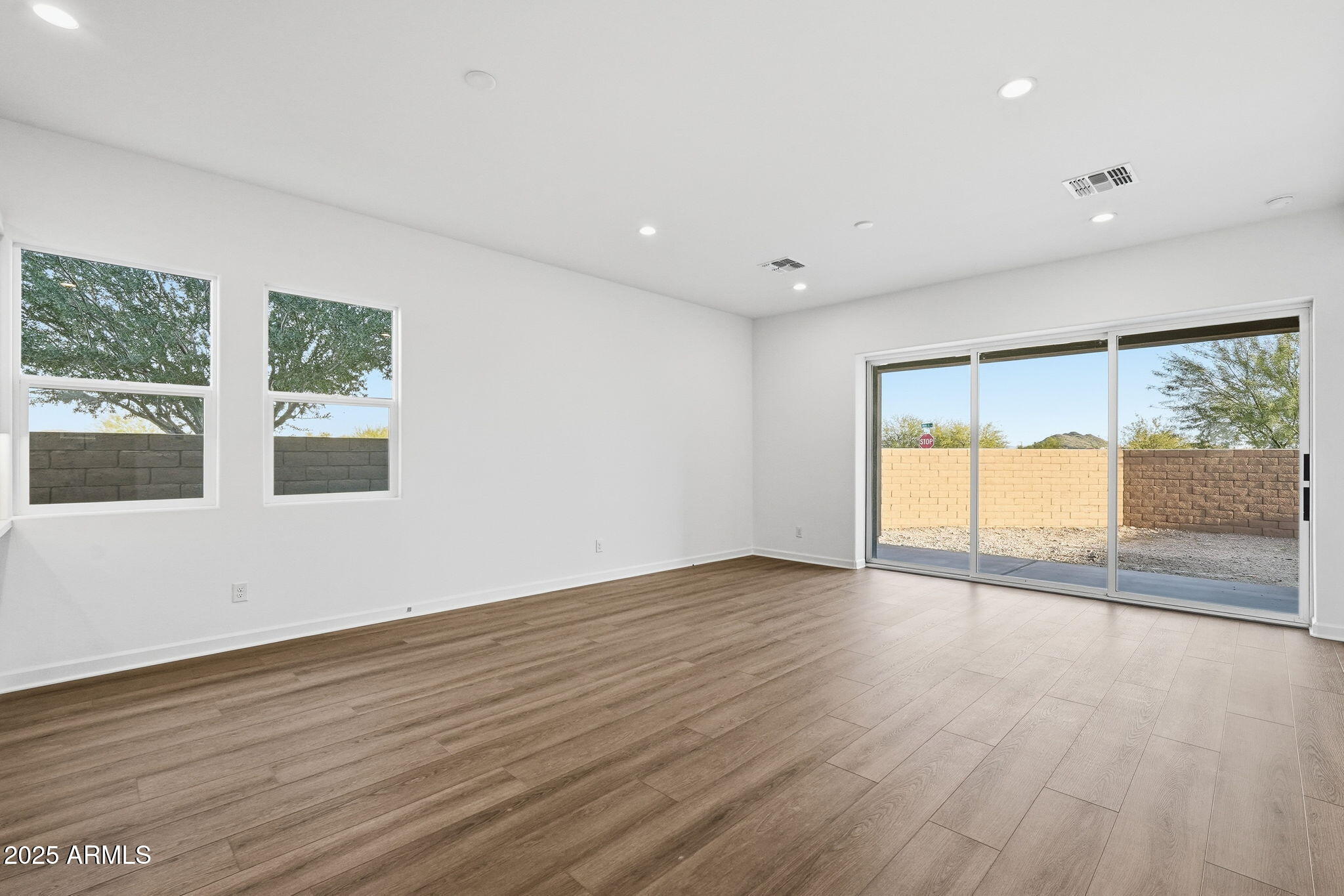17927 West Long Lake Road Goodyear, AZ 85338 - Photo 24 of 36 a view of an empty room with wooden floor and a window