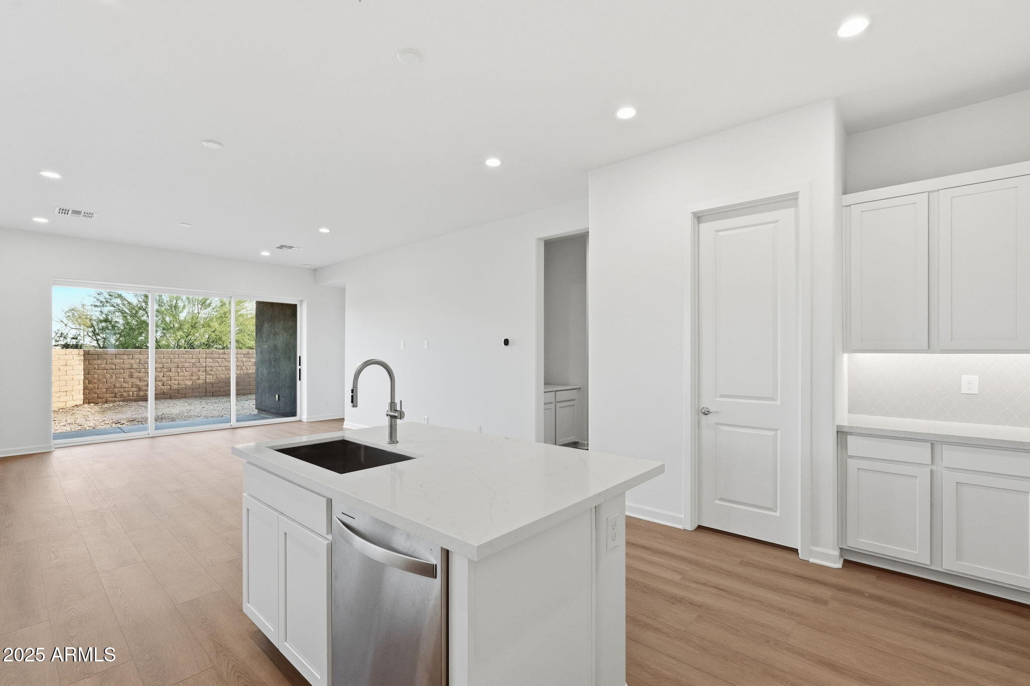 17927 West Long Lake Road Goodyear, AZ 85338 - Photo 7 of 36 a kitchen with a sink a counter space and wooden floor