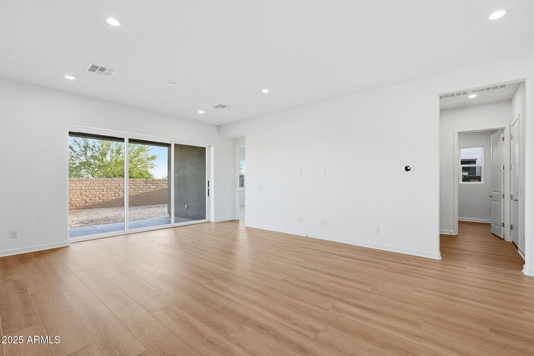 17927 West Long Lake Road Goodyear, AZ 85338 - Photo 9 of 36 a view of an empty room with wooden floor and a window