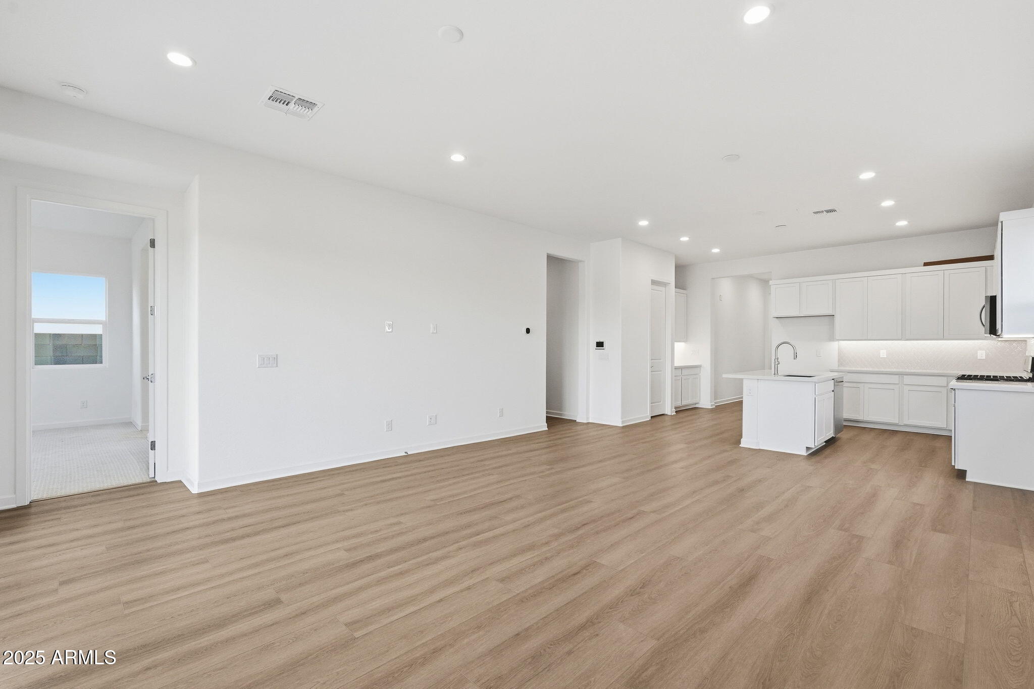 17927 West Long Lake Road Goodyear, AZ 85338 - Photo 10 of 36 an empty room with wooden floor and windows