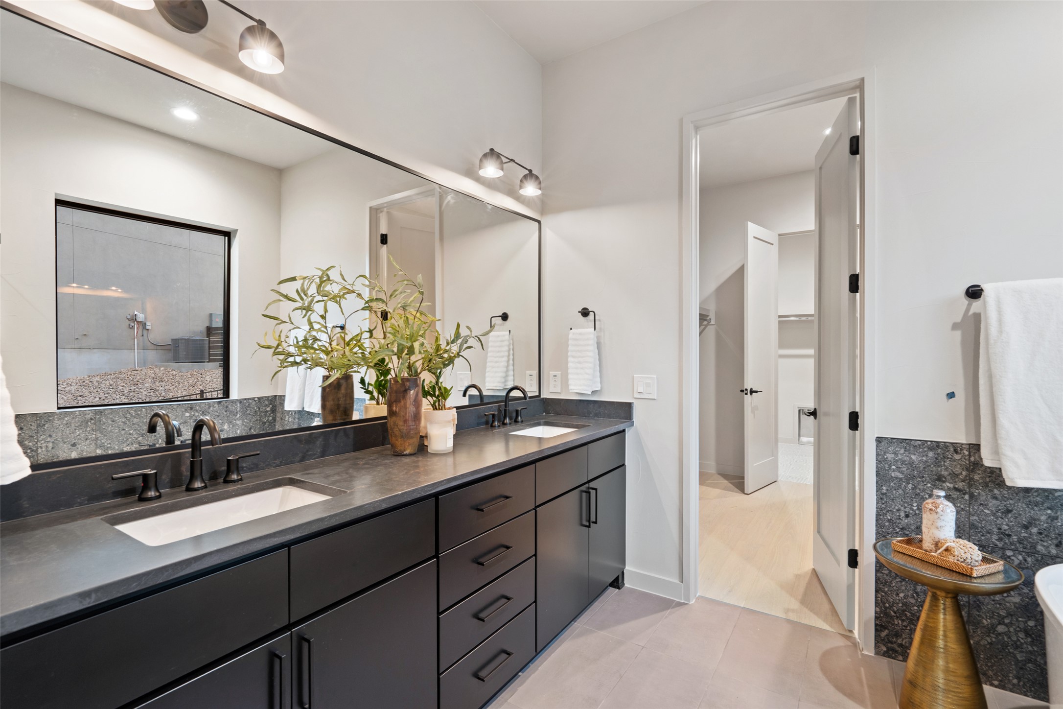 9803 Ribelin Ranch Court, Unit 6 Austin, TX 78750 - Photo 13 of 31 A chic primary bathroom vanity with dual sinks, modern dark cabinetry, and stone counters provides a functional oasis.