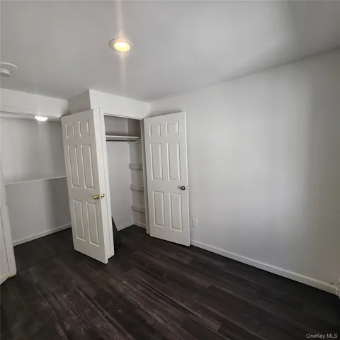 an empty room with wooden floor and white wall