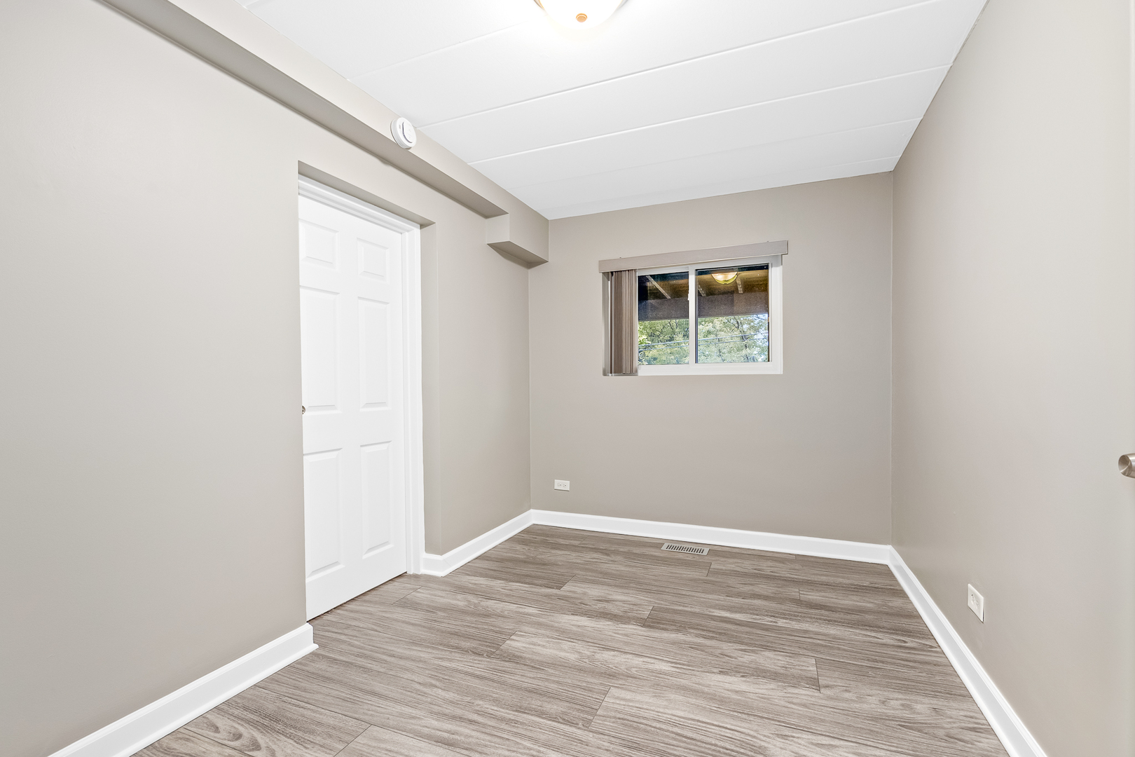 332 Maple Avenue, Unit 1 Downers Grove, IL 60515 - Photo 16 of 29 an empty room with wooden floor and windows