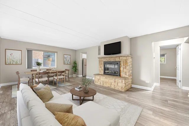 a living room with furniture a flat screen tv and a fireplace