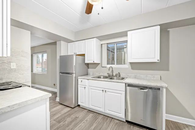 a kitchen with white cabinets and sink