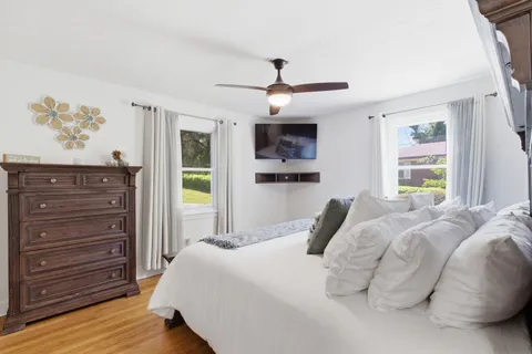 a bedroom with a bed a dresser and a window