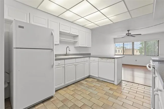 a kitchen with a sink a refrigerator and cabinets