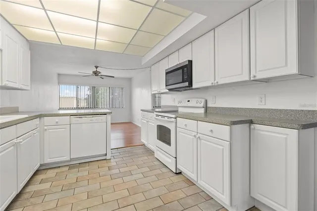 a kitchen with white cabinets appliances and a sink