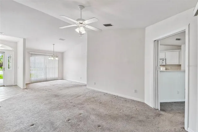 an empty room with fan and entrance