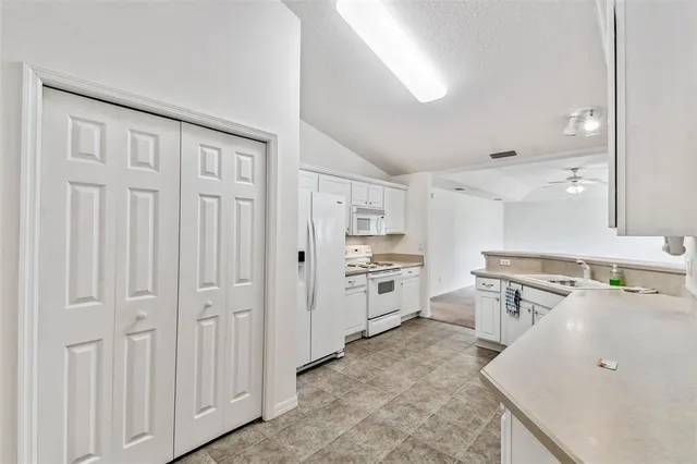 a kitchen with white cabinets and stainless steel appliances