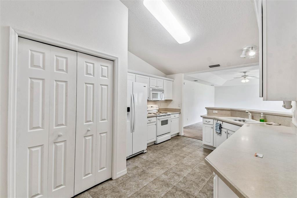 142 Morning Glory Circle Winter Haven, FL 33884 - Photo 15 of 36 a kitchen with white cabinets and stainless steel appliances