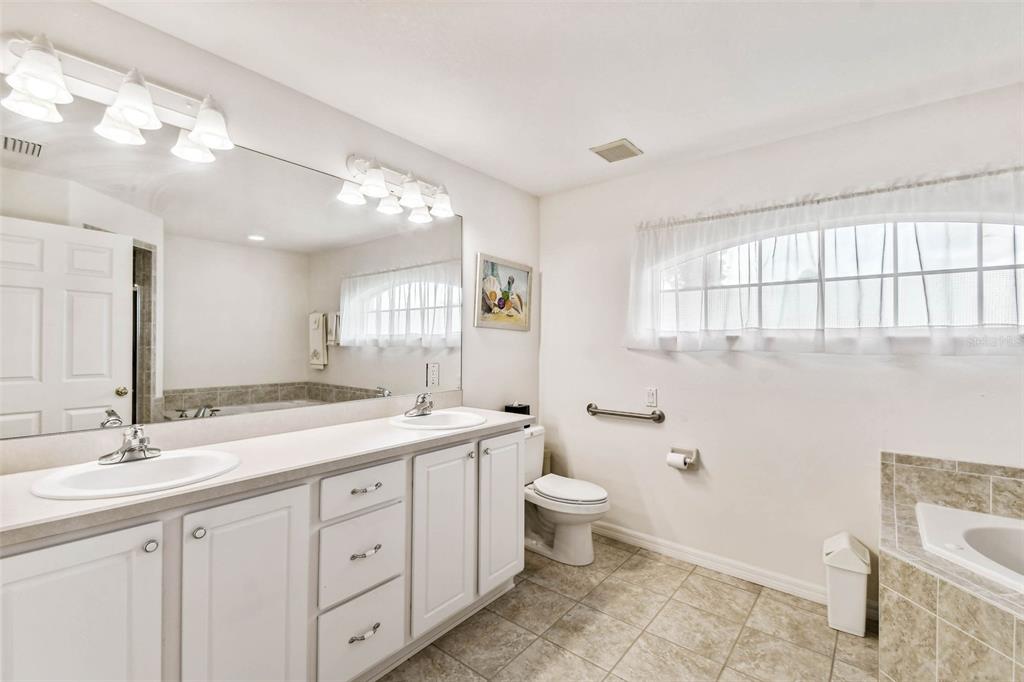 142 Morning Glory Circle Winter Haven, FL 33884 - Photo 19 of 36 a spacious bathroom with a double vanity sink a toilet and a mirror