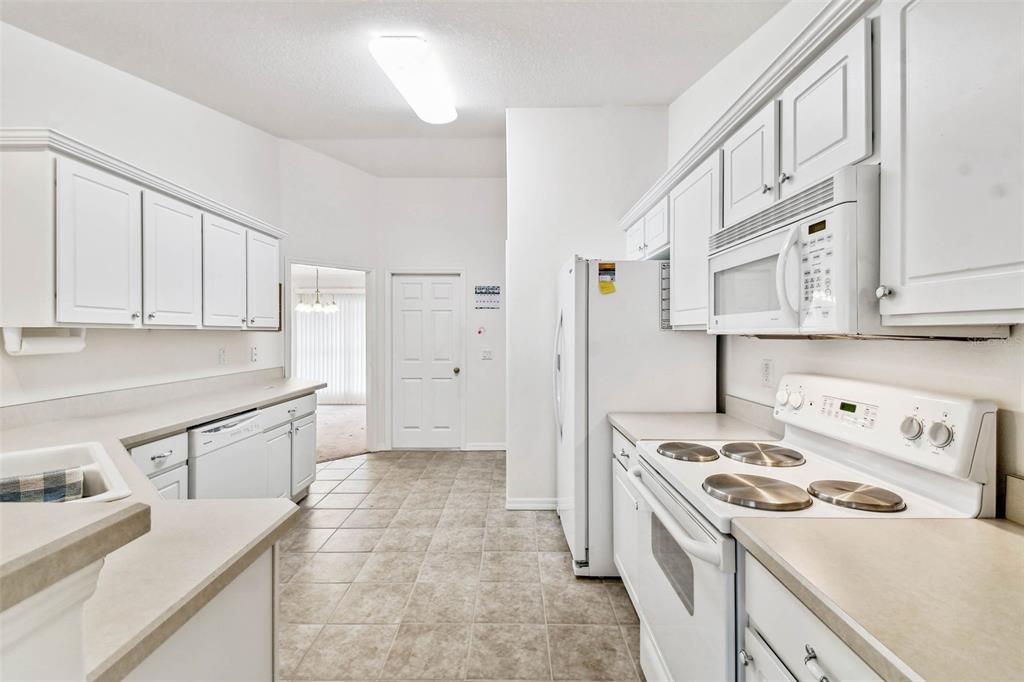 142 Morning Glory Circle Winter Haven, FL 33884 - Photo 5 of 36 a kitchen with a sink stove and refrigerator