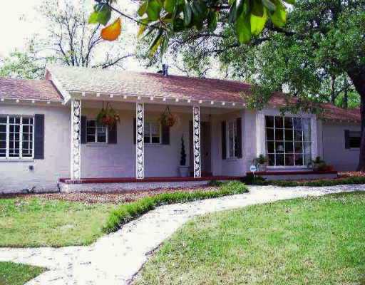 a front view of a house with a yard and potted plants