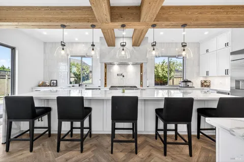 a kitchen with white cabinets and sink