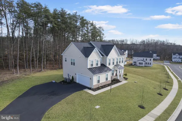 a view of a house with a big yard and large trees