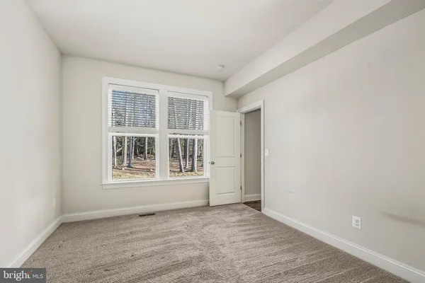 an empty room with closet and a ceiling fan