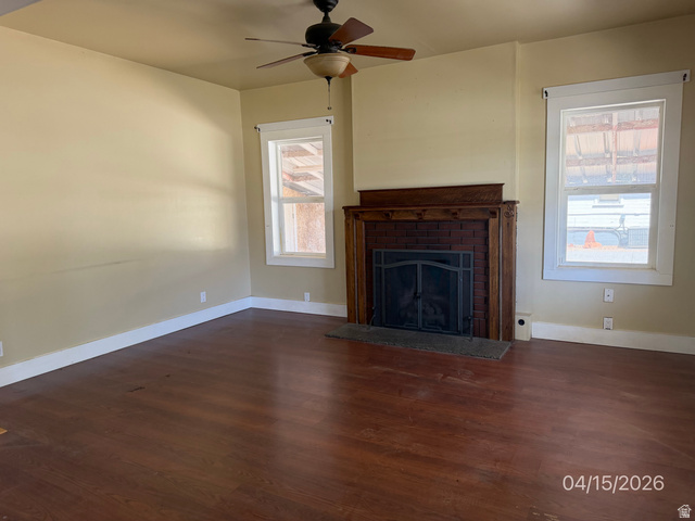 250 South Main Street Fillmore, UT 84631 - Photo 5 of 12 Unfurnished living room featuring dark wood finished floors, a fireplace, and ceiling fan