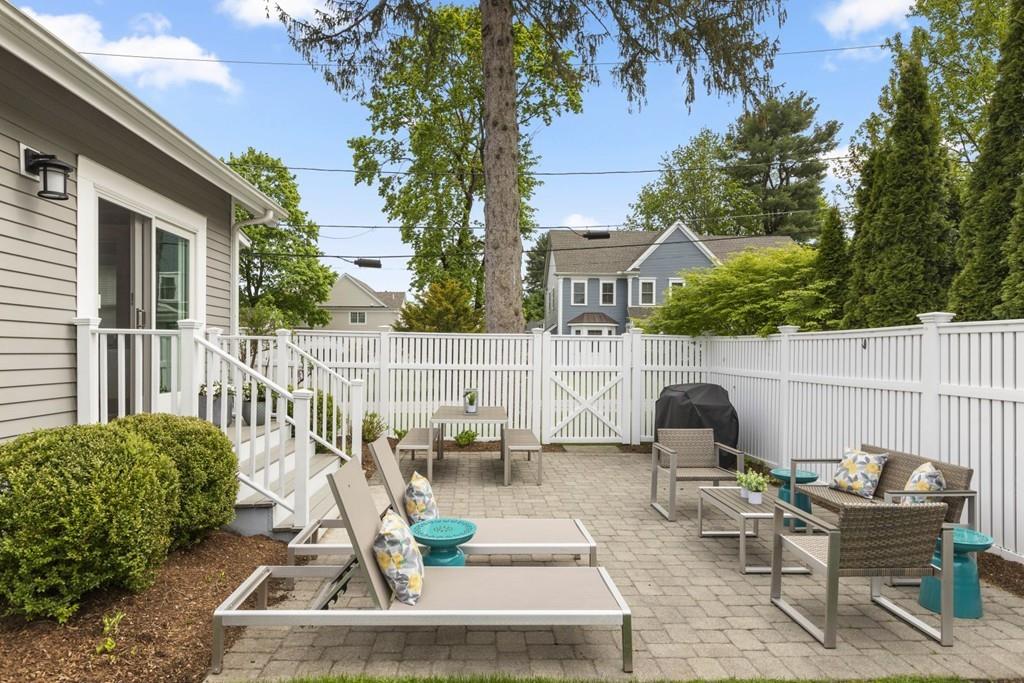 4 Bryn Mawr Road Wellesley, MA 02482 - Photo 21 of 27 a view of a chair and tables in the back yard of the house