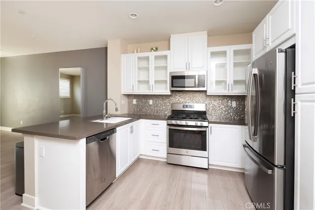 a kitchen with stainless steel appliances granite countertop a refrigerator and a stove top oven