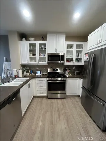 a kitchen with granite countertop a refrigerator stove and sink