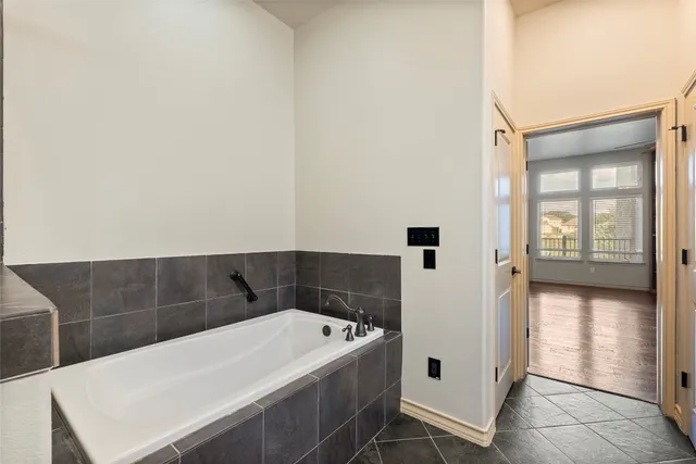 a bathroom with a double vanity sink a mirror and a bathtub