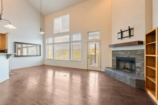 wooden floor fireplace and windows in an empty room