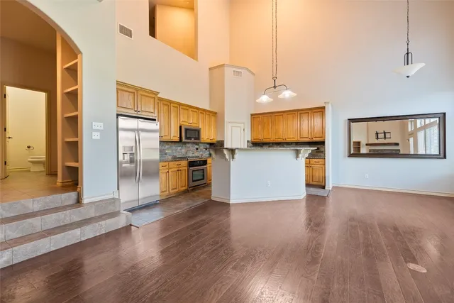 a kitchen with stainless steel appliances wooden floor and large windows
