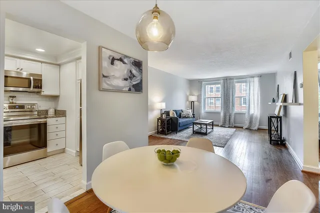 a living room with stainless steel appliances furniture a fireplace and a flat screen tv