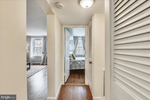 a view of a hallway with wooden floor and staircase