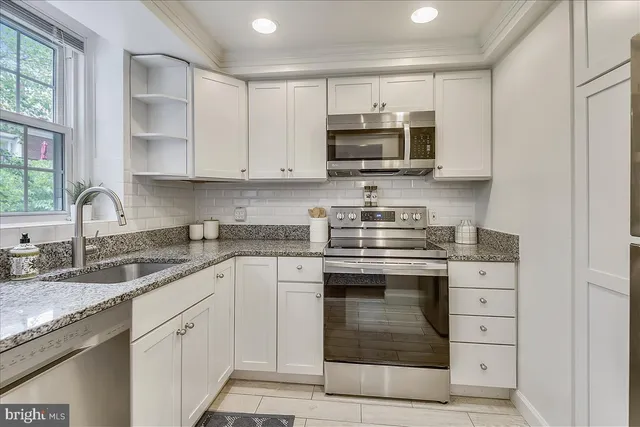 a kitchen with stainless steel appliances granite countertop a sink and a stove