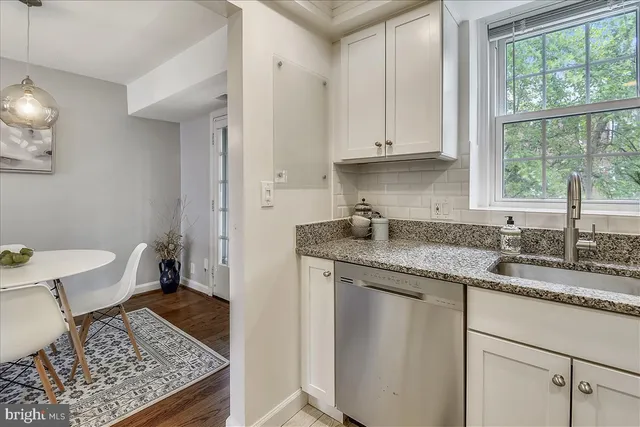 a kitchen with granite countertop a sink stove and cabinets