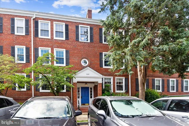 a front view of a house with garden and trees