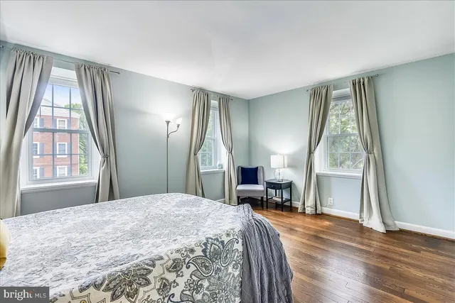 a bedroom with a bed and large windows