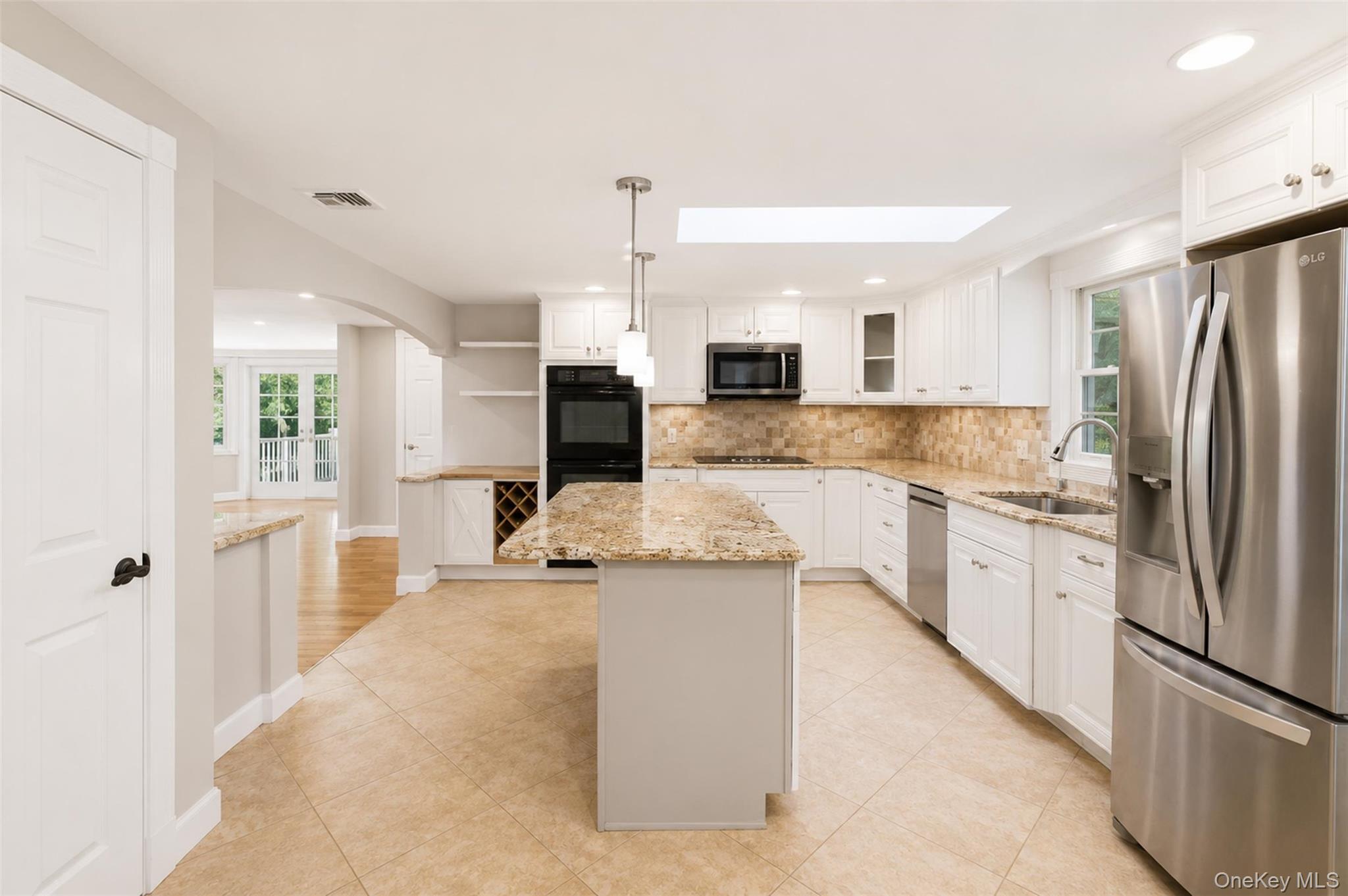 12 Leeside Road Carmel, NY 10512 - Photo 8 of 44 Spacious kitchen featuring an island with granite countertops, tile flooring, white cabinetry, stainless steel appliances, and a skylight