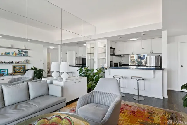 a living room with furniture kitchen view and a potted plant