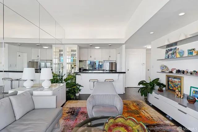 a living room with furniture and a view of kitchen