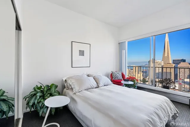 a spacious bedroom with a bed and a table chair