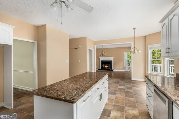 a kitchen with kitchen island a counter top space a sink a refrigerator and a counter top space