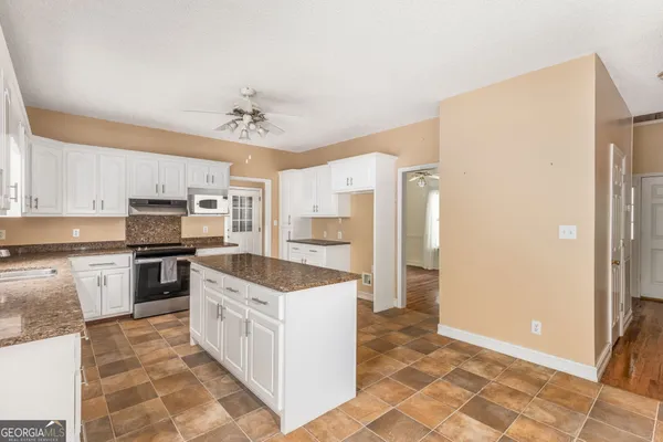a kitchen with stainless steel appliances granite countertop a refrigerator and a stove top oven