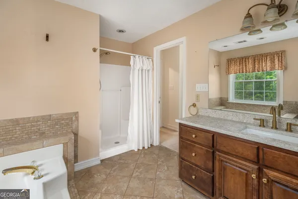 a bathroom with a granite countertop sink a mirror and a shower
