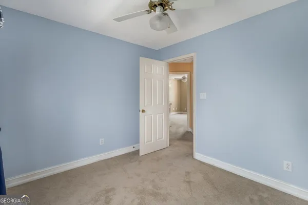 an empty room and a chandelier fan