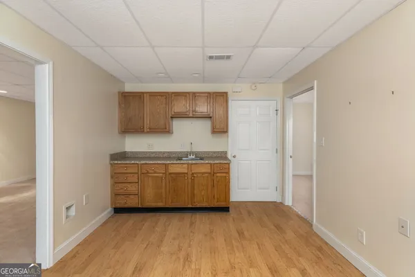 a room with granite countertop white cabinets and wooden floor