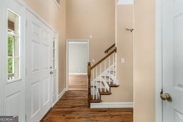 a view of a hallway with wooden floor and staircase