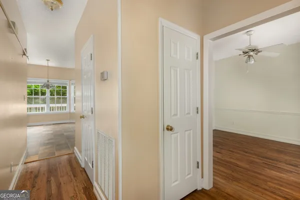 a view of a hallway with wooden floor and closet